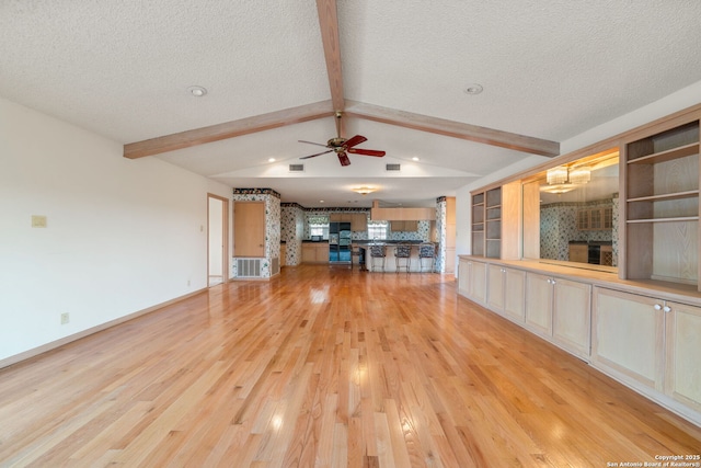 831 Hill Top, Canyon Lake, TX 78133 - unfurnished living room featuring light wood-type flooring, baseboards, a textured ceiling, ceiling fan, and vaulted ceiling with beams
