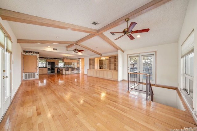 831 Hill Top, Canyon Lake, TX 78133 - unfurnished living room with light wood finished floors, vaulted ceiling with beams, visible vents, and ceiling fan