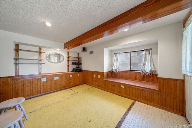 831 Hill Top, Canyon Lake, TX 78133 - kitchen featuring a wainscoted wall, a textured ceiling, wooden walls, and beamed ceiling