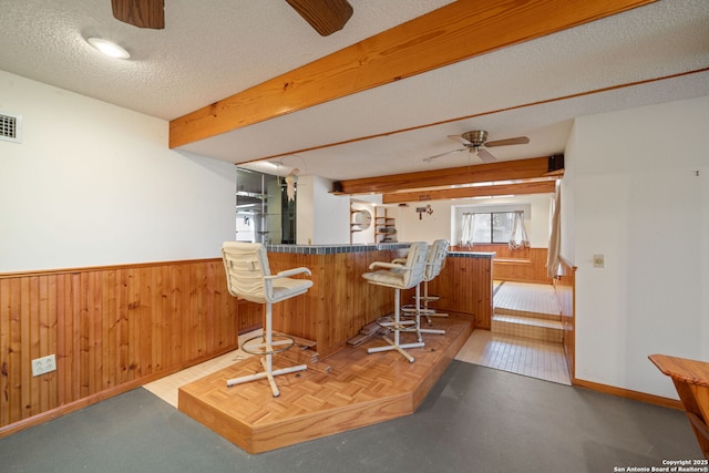 831 Hill Top, Canyon Lake, TX 78133 - kitchen with wood walls, a textured ceiling, beamed ceiling, a ceiling fan, and wainscoting