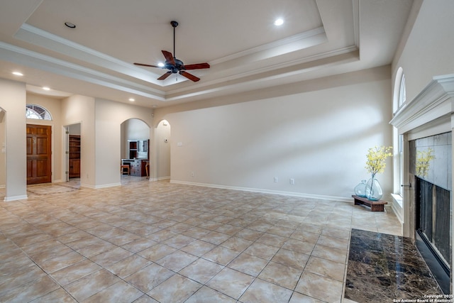 14834 Churchill Estates Blvd, San Antonio, TX 78248 - unfurnished living room featuring a raised ceiling, a premium fireplace, arched walkways, ceiling fan, and recessed lighting