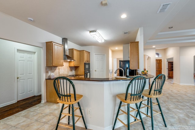14834 Churchill Estates Blvd, San Antonio, TX 78248 - kitchen with wall chimney range hood, dark countertops, tasteful backsplash, a breakfast bar, and recessed lighting