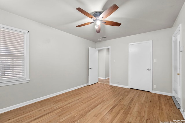 unfurnished bedroom with baseboards, visible vents, light wood-style floors, and a ceiling fan