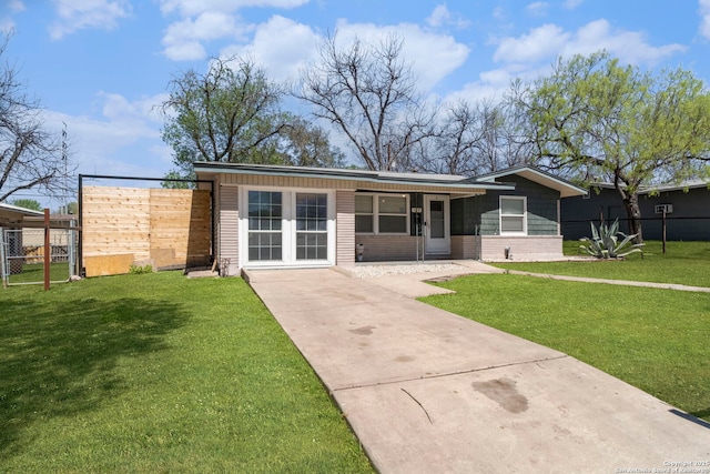 view of front of home featuring a front yard, fence, and concrete driveway