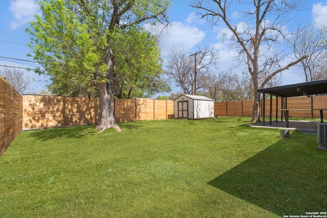view of yard featuring a fenced backyard, an outbuilding, and a storage shed