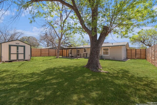 view of yard featuring a fenced backyard, an outbuilding, and a storage shed