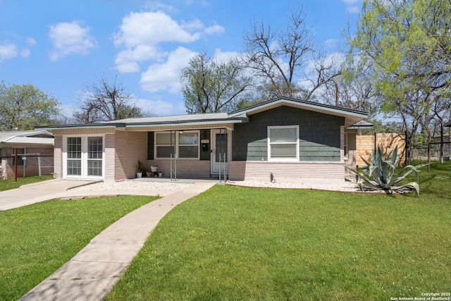 view of front of home with a front lawn, fence, and french doors