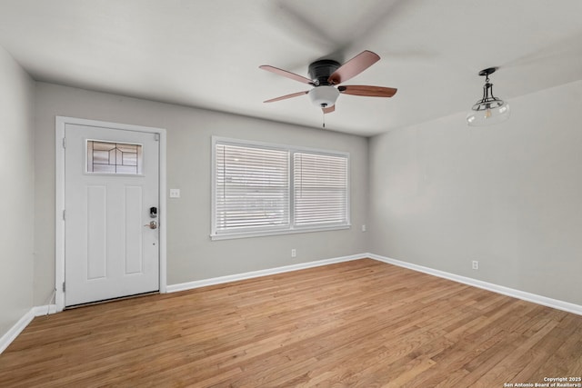 foyer featuring baseboards, light wood-type flooring, and a ceiling fan