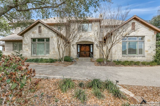 7 Oxford Hall, San Antonio, TX 78209 - view of front of property with a standing seam roof, metal roof, stone siding, and a chimney