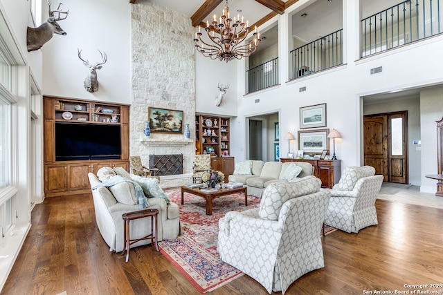 7 Oxford Hall, San Antonio, TX 78209 - living room with a towering ceiling, a chandelier, wood-type flooring, a stone fireplace, and beamed ceiling