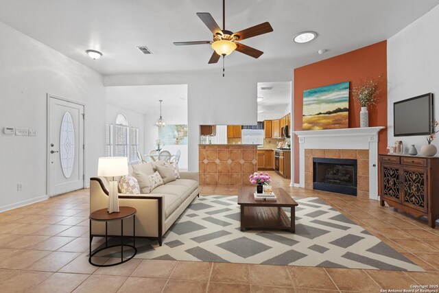 6615 Morning Shadow, San Antonio, TX 78256 - living area with a fireplace, visible vents, ceiling fan, and light tile patterned floors