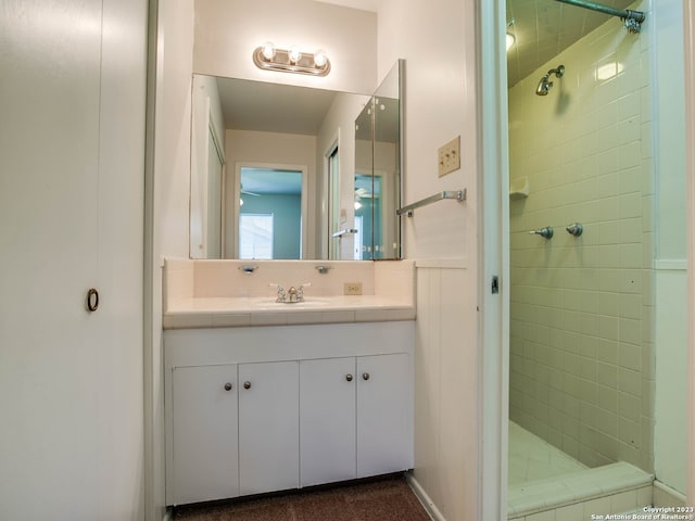 bathroom featuring tiled shower and vanity
