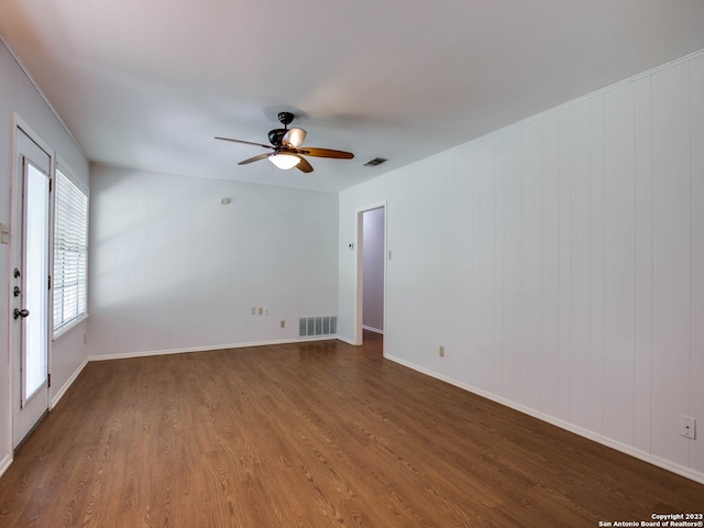 unfurnished room featuring visible vents, wood finished floors, and ceiling fan