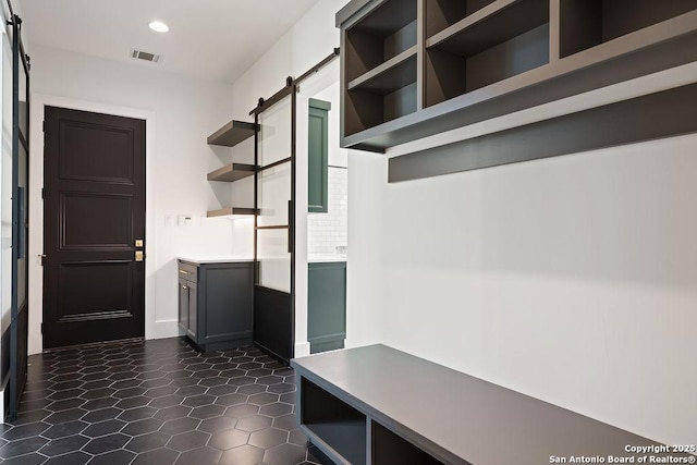 mudroom with a barn door, visible vents, and recessed lighting