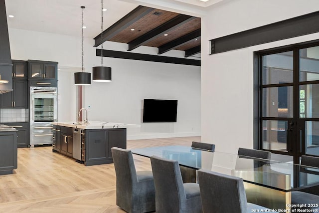 unfurnished dining area with parquet floors, beam ceiling, and a sink