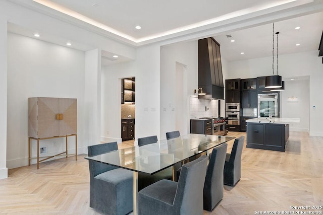 dining space with recessed lighting, a towering ceiling, and baseboards