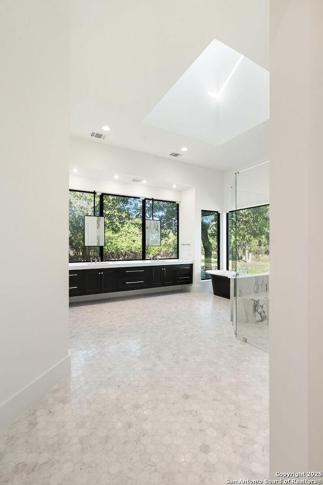unfurnished living room featuring recessed lighting, visible vents, baseboards, and a healthy amount of sunlight