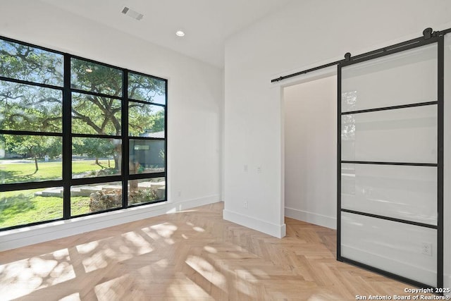 unfurnished bedroom with a barn door, baseboards, visible vents, and recessed lighting