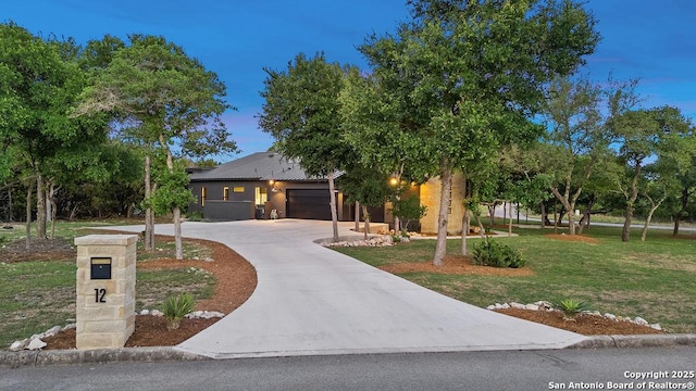 view of front of home featuring driveway, a front yard, and a garage