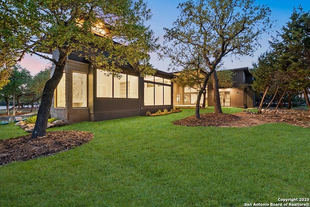 exterior space with stucco siding and a front yard