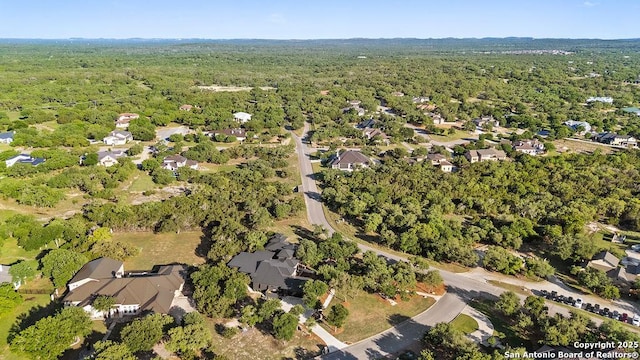 bird's eye view featuring a residential view and a wooded view