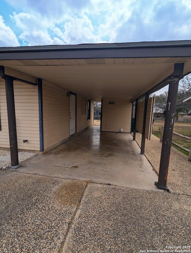 view of vehicle parking with a carport and aphalt driveway