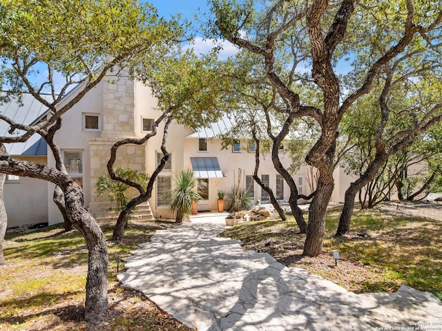 view of front facade featuring stucco siding and stone siding