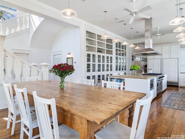 dining area with ceiling fan and dark wood-style floors