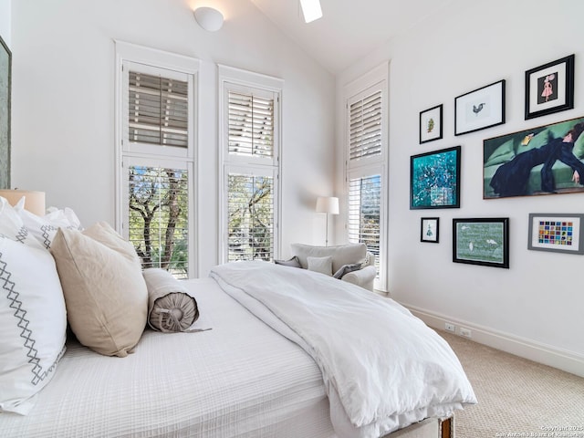 carpeted bedroom with baseboards, vaulted ceiling, and multiple windows