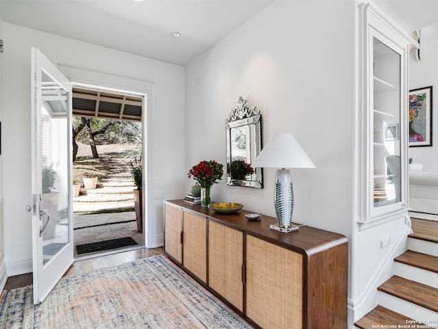 doorway to outside featuring baseboards, recessed lighting, light wood-style flooring, and stairs