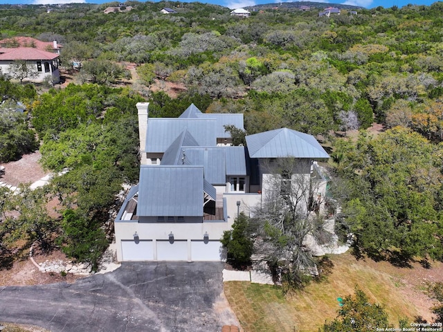birds eye view of property featuring a wooded view