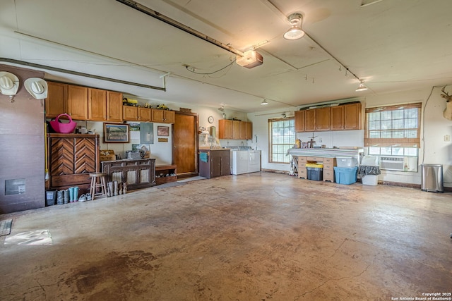 garage with independent washer and dryer and a garage door opener