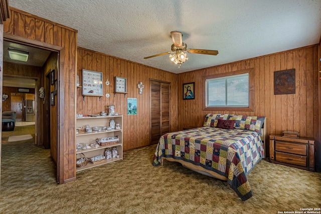 carpeted bedroom featuring a closet, ceiling fan, and a textured ceiling