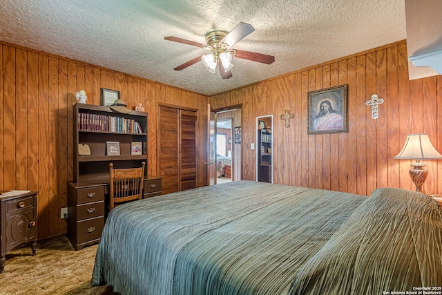 bedroom featuring a closet, carpet floors, a ceiling fan, wood walls, and a textured ceiling