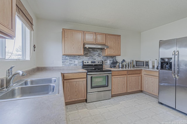 4907 Heather Pass, San Antonio, TX 78218 - kitchen with light countertops, stainless steel appliances, under cabinet range hood, a sink, and light floors