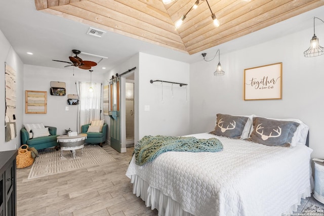 608 W Morse St, Fredericksburg, TX 78624 - bedroom featuring light wood finished floors, a barn door, rail lighting, and recessed lighting