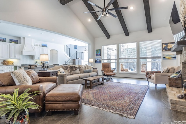 living room featuring stairway, high vaulted ceiling, arched walkways, a ceiling fan, and wood finished floors