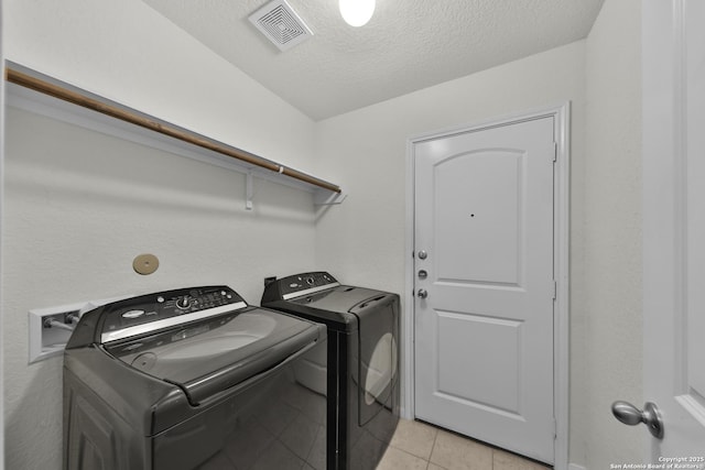 12266 Stratsburg, San Antonio, TX 78252 - laundry room featuring a textured ceiling, laundry area, light tile patterned floors, independent washer and dryer, and visible vents