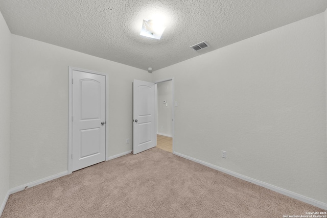 12266 Stratsburg, San Antonio, TX 78252 - unfurnished bedroom with light carpet, baseboards, visible vents, and a textured ceiling