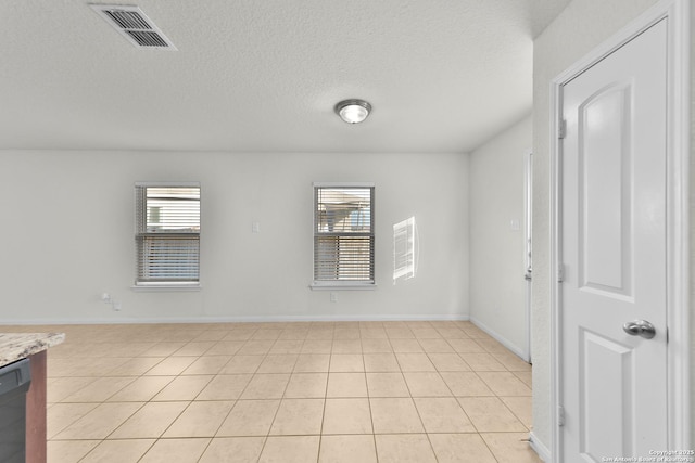 12266 Stratsburg, San Antonio, TX 78252 - empty room with light tile patterned flooring, a textured ceiling, visible vents, and a healthy amount of sunlight