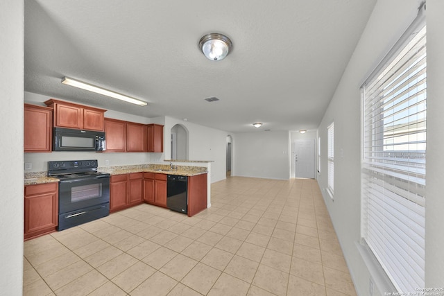 12266 Stratsburg, San Antonio, TX 78252 - kitchen with a peninsula, a sink, light stone counters, open floor plan, and black appliances