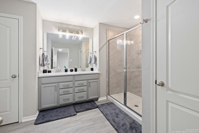 1623 Iron Crk, San Antonio, TX 78245 - bathroom featuring an inviting chandelier, double vanity, a sink, and a stall shower