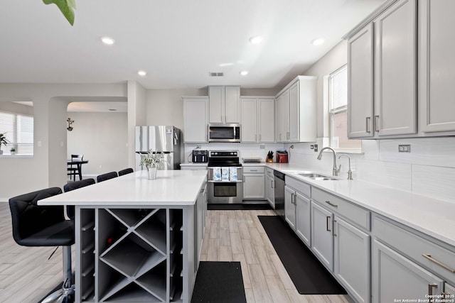 1623 Iron Crk, San Antonio, TX 78245 - kitchen featuring tasteful backsplash, a breakfast bar area, a healthy amount of sunlight, a sink, and appliances with stainless steel finishes