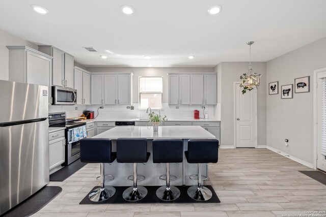1623 Iron Crk, San Antonio, TX 78245 - kitchen with light countertops, visible vents, stainless steel appliances, tasteful backsplash, and a breakfast bar area