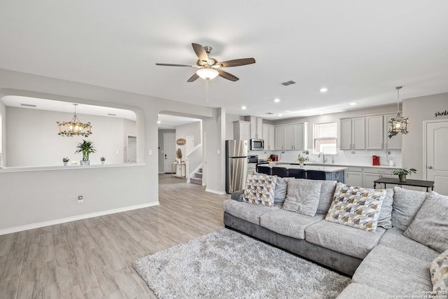 1623 Iron Crk, San Antonio, TX 78245 - living area with stairway, a ceiling fan, light wood finished floors, baseboards, and visible vents