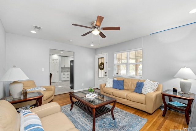 living room featuring light wood-type flooring, baseboards, visible vents, ceiling fan, and recessed lighting