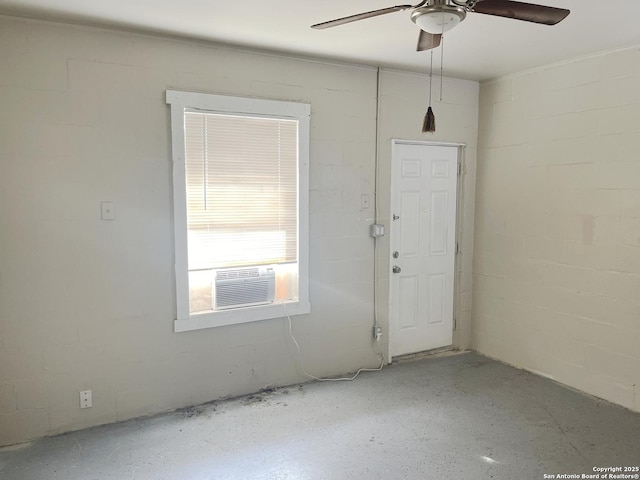 unfurnished room with concrete block wall, cooling unit, and ceiling fan
