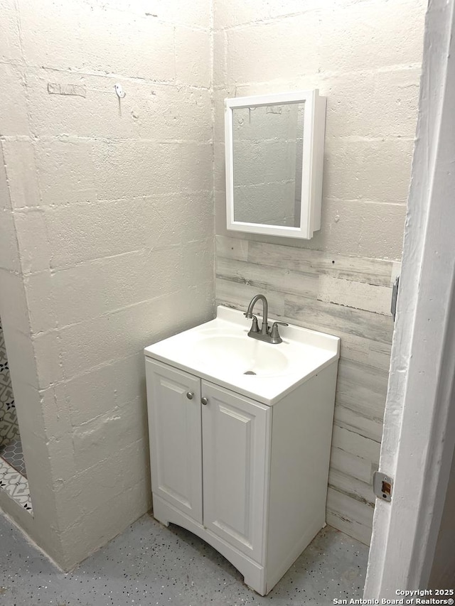 bathroom with concrete block wall and vanity