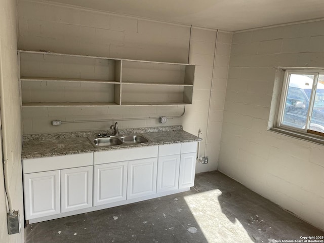bathroom with concrete block wall and vanity