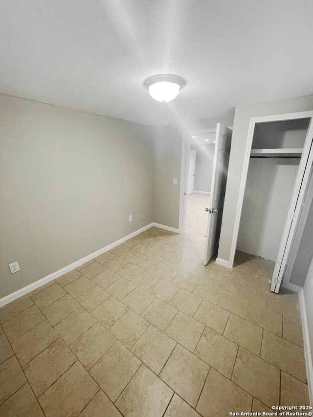 unfurnished bedroom featuring a closet and baseboards